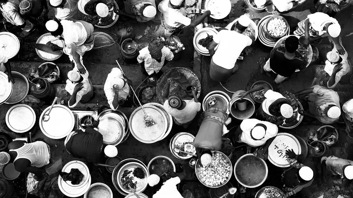 A large group of people seated at a table, surrounded by an assortment of dishes and food.